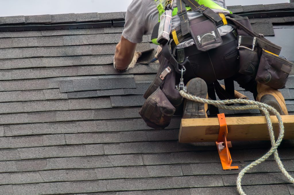 Roof Repair 4 professional repair construction worker man roofer working on roof maintenance safety with secure rope