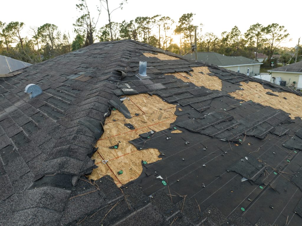Roof Repair 3 Natural disaster and its consequences. Hurricane Ian destroyed house roof in Florida residential area.